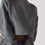 A close up shot of the cropped hem and fabric on a grey crew neck jumper