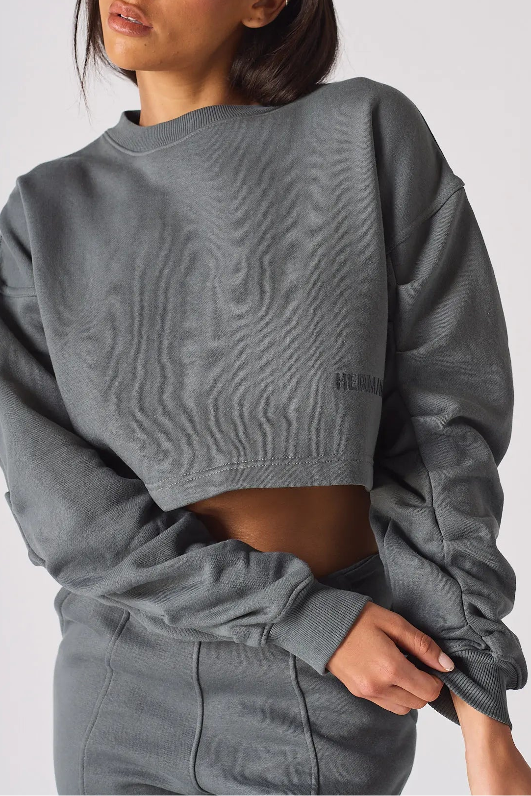 Close up detail of the unique ruched sleeves on a charcoal grey jumper
