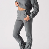 Side profile of a woman wearing a grey cropped jumper and matching joggers