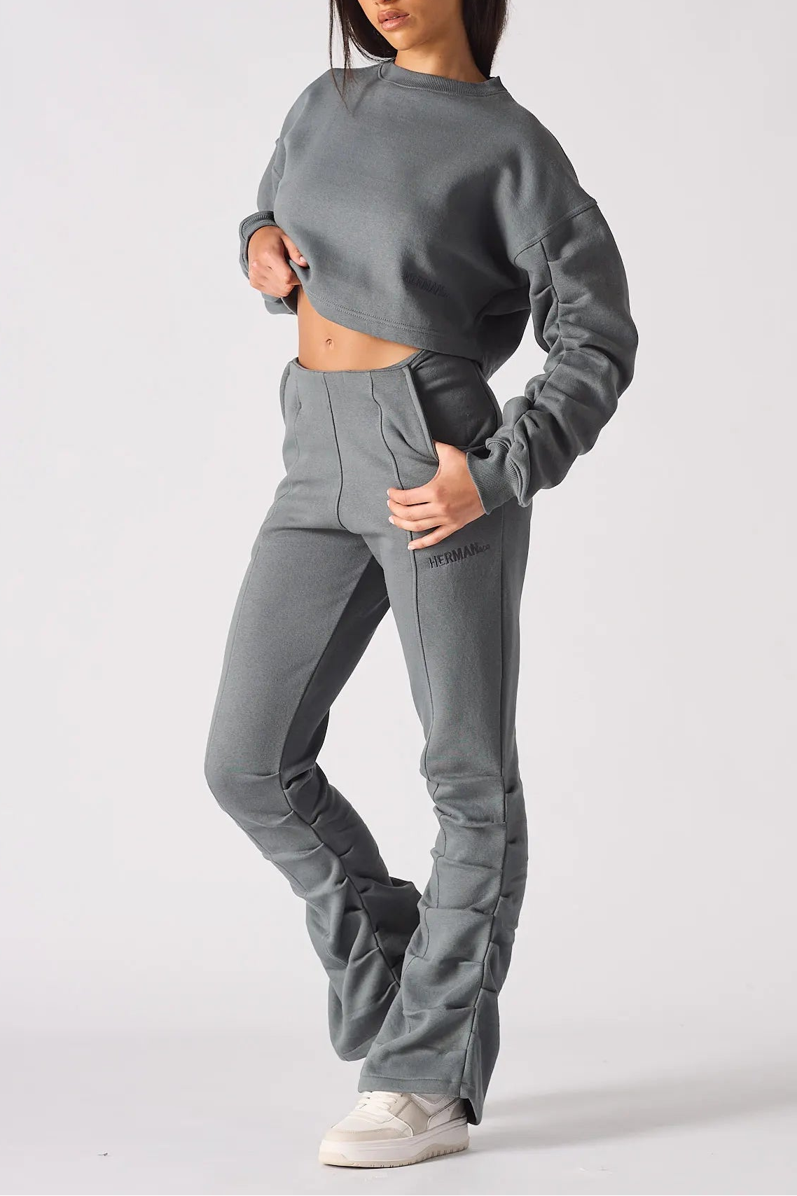 Side profile of a woman wearing a grey cropped jumper and matching joggers