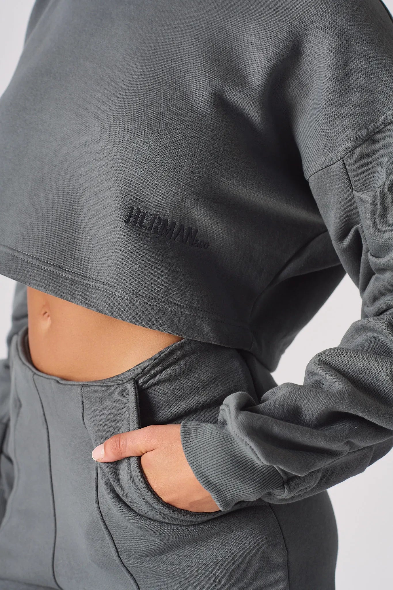 A detailed look at the soft charcoal grey fabric and the cropped fit at the waist