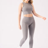 Front angle of a woman styling a grey crop top for women with trainers