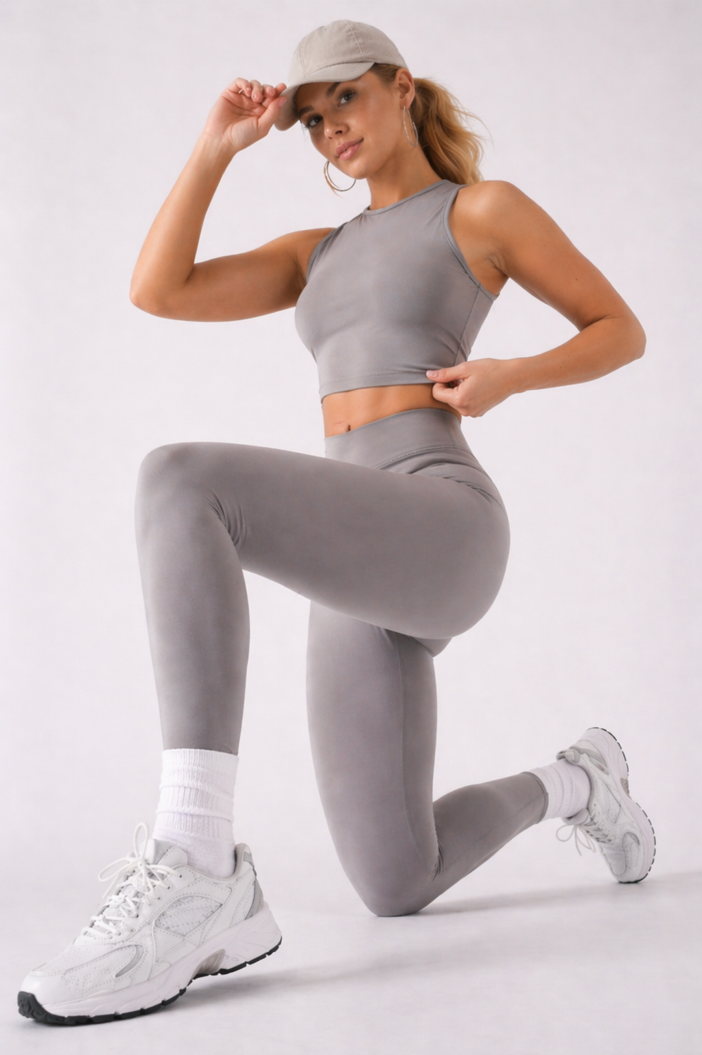 A woman wearing womens-grey-racerback-training-crop-top in a kneeling lunge pose showing the fitted cut