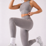 A woman wearing womens-grey-racerback-training-crop-top in a kneeling lunge pose showing the fitted cut