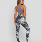 A woman wearing womens-grey-tie-dye-high-waist-leggings back view showing the fit and print detail, paired with a purple crop top