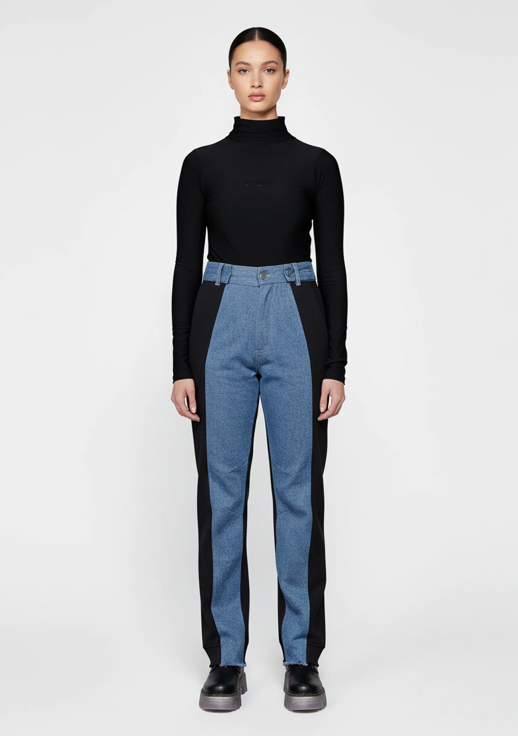 Front view of women's high-rise dual color denim featuring light blue front and black side panels.