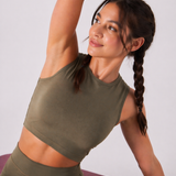 A woman wearing womens-khaki-high-waist-biker-shorts with arm raised in a stretch showing the fitted cut and cropped top