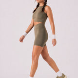 A woman wearing womens-khaki-high-waist-biker-shorts walking side view showing the mid thigh length and fitted cut