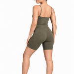 A woman wearing womens-khaki-strappy-unitard back view showing the thin straps and butt lifting biker short length