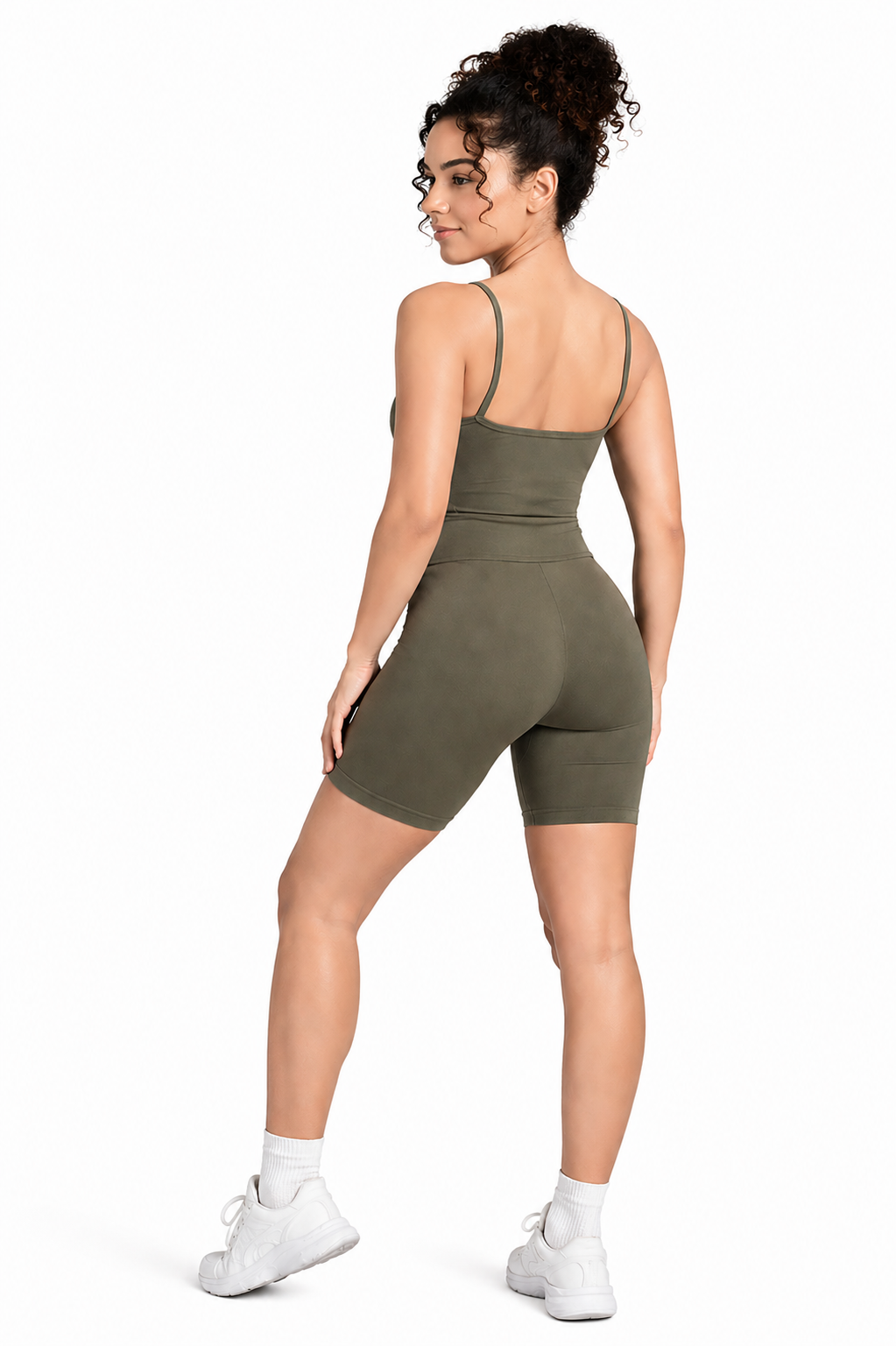 A woman wearing womens-khaki-strappy-unitard back view showing the thin straps and butt lifting biker short length