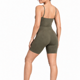 A woman wearing womens-khaki-strappy-unitard back view showing the thin straps and butt lifting biker short length