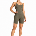 A woman wearing womens-khaki-strappy-unitard front view showing the scoop neckline and smooth tummy control panel