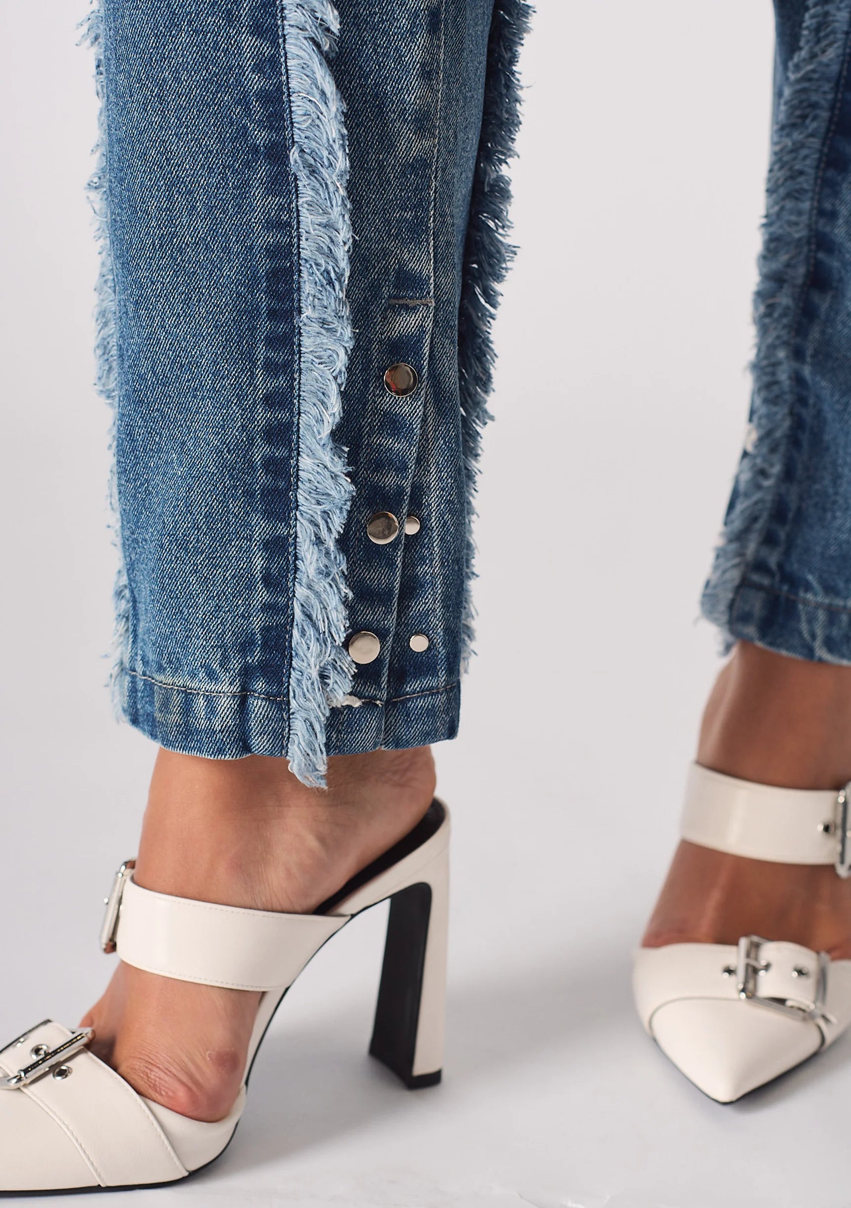 Silver popper hem detail on Womens Mid Blue Wash frayed seam jeans