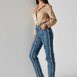 Side profile walk of Womens Mid Blue Wash frayed seam jeans