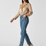 Walking view of Womens Mid Blue Wash frayed seam straight leg jeans