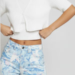 Model standing with arms crossed in women's psychedelic wash straight leg pants.