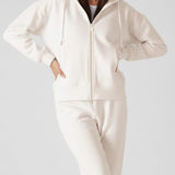 A woman wearing a stylish womens white zip up hoodies in a front view.