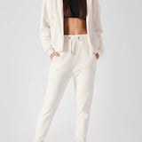Full length shot of a model wearing womens white zip up hoodies and matching joggers.