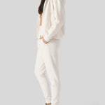 Side profile of a model posing in comfortable womens white zip up hoodies.