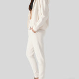 Side profile of a model posing in comfortable womens white zip up hoodies.