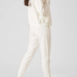 Rear view of a model walking while wearing womens white zip up hoodies.