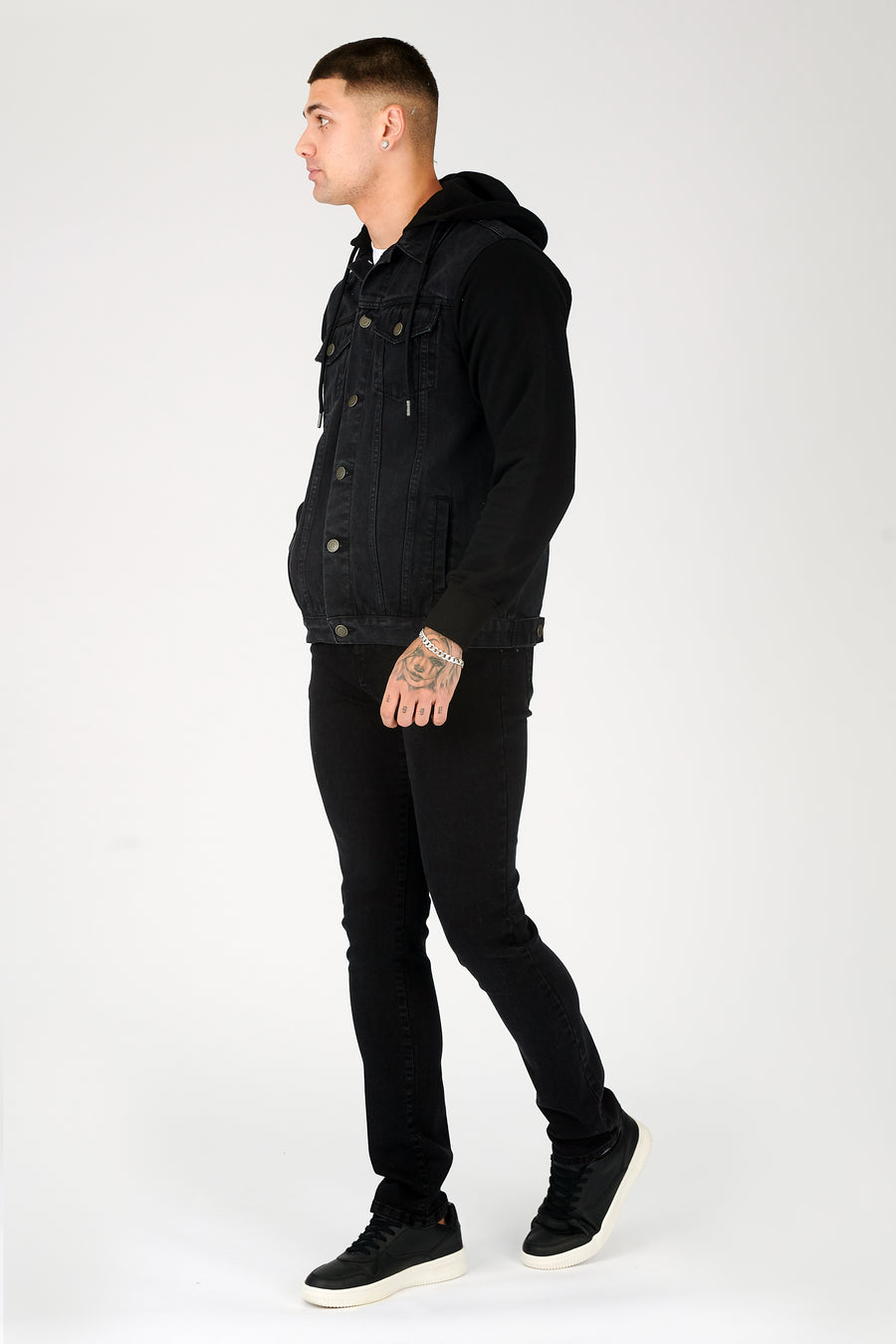 Full body side shot of a standing male model wearing a JMOJO Black Wash Hooded Fleece Denim Jacket
