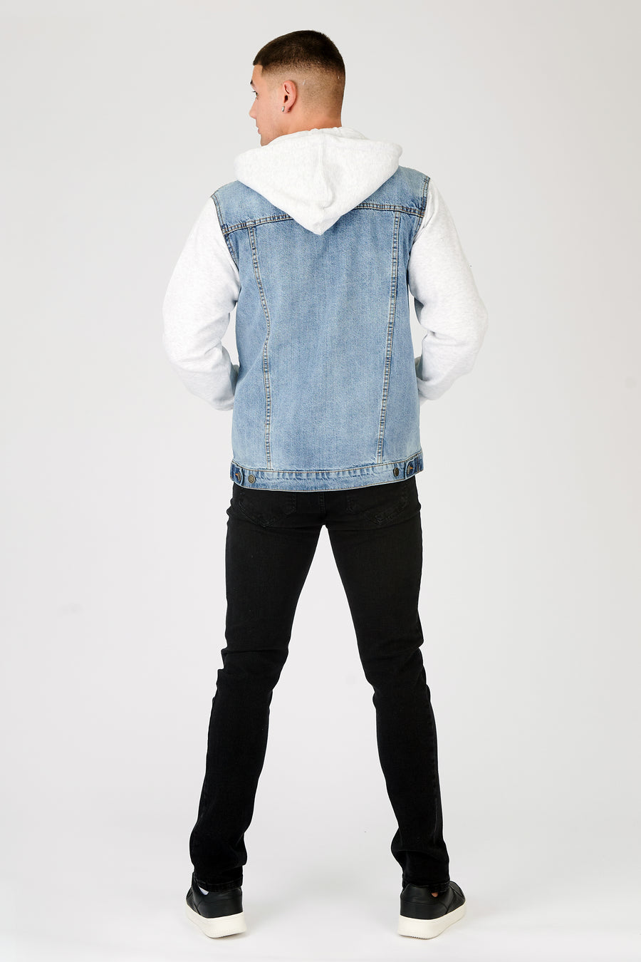 Full body back shot of a standing male model wearing a JMOJO Light Blue Wash Hooded Fleece Denim Jacket