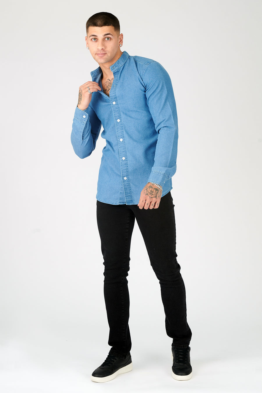 Body shot of a standing male model wearing a JMOJO Blue Slim Fit Grandad Collar Denim Shirt