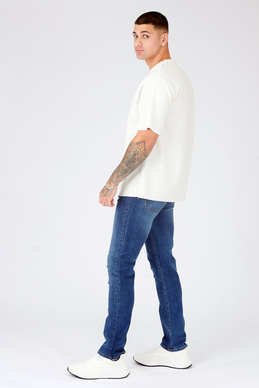 Full body shot of a standing male model wearing JMOJO Mid Blue Wash Slim Fit Denim Jeans