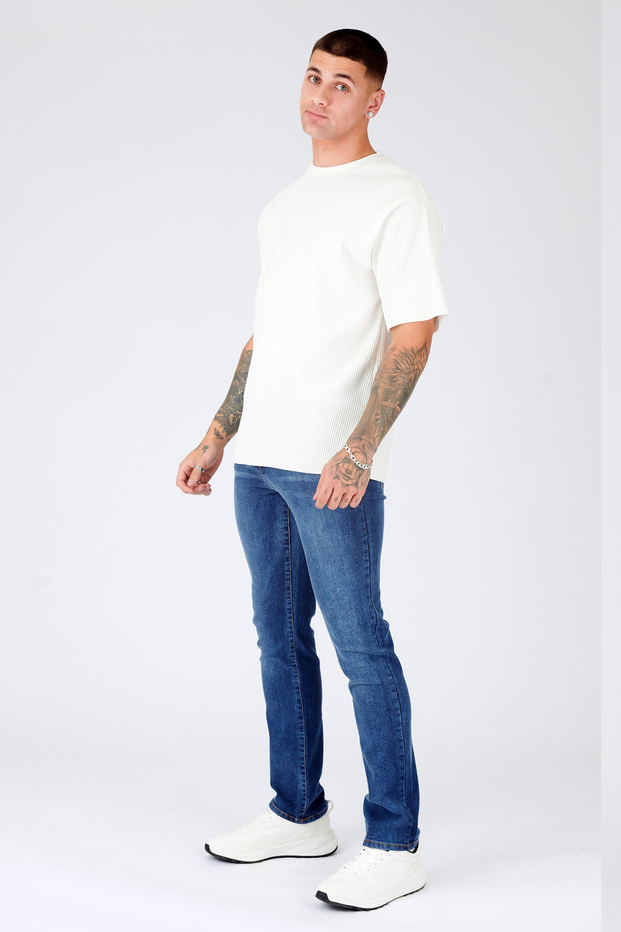 Full body shot of a standing male model wearing JMOJO Mid Blue Wash Slim Fit Denim Jeans
