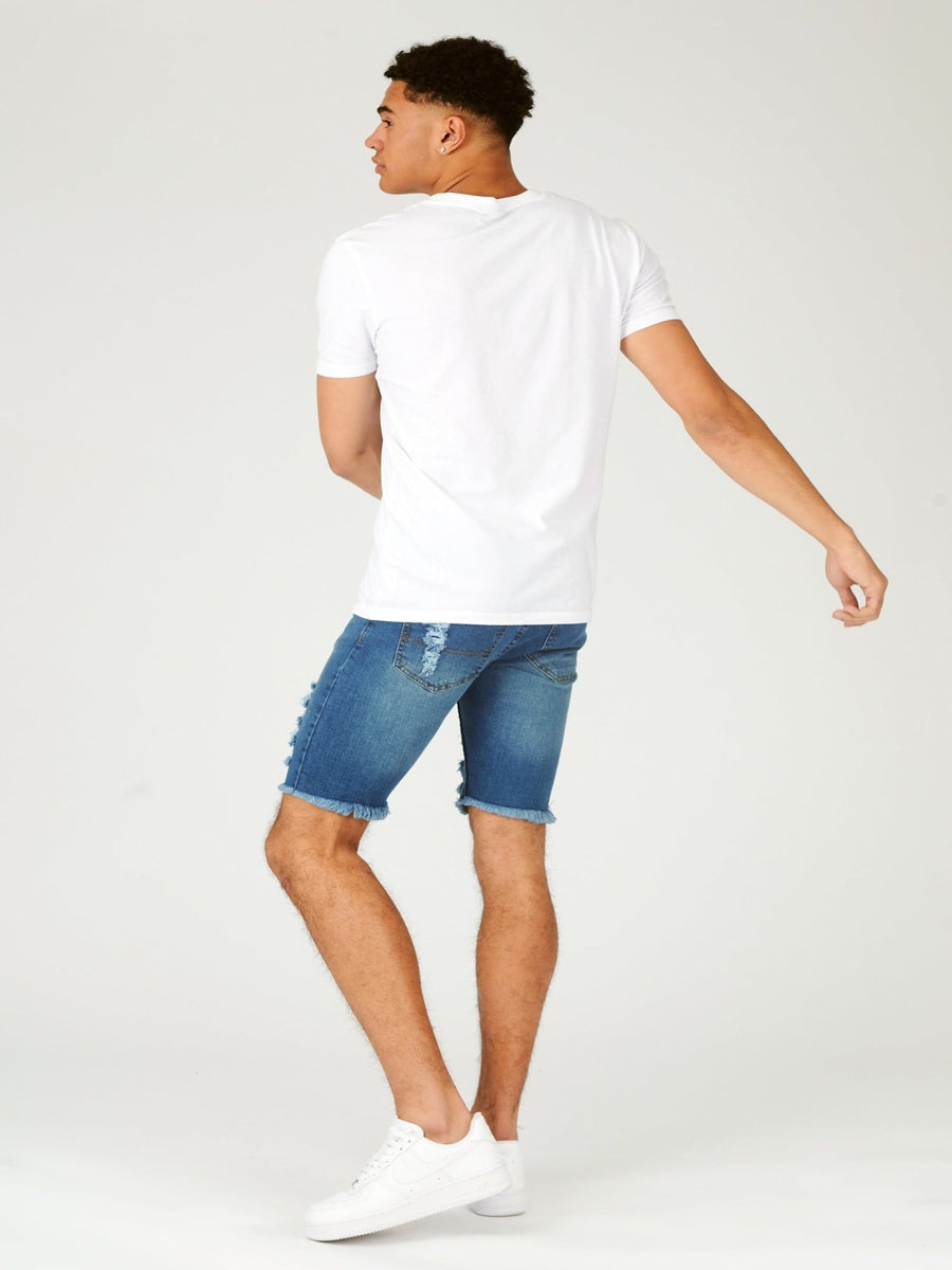 Full body shot of a standing male model wearing JMOJO Light Blue Wash Slim Fit Ripped Denim Shorts