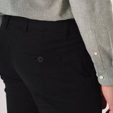 Detail shot of the back pocket on black slim fit chinos trousers.