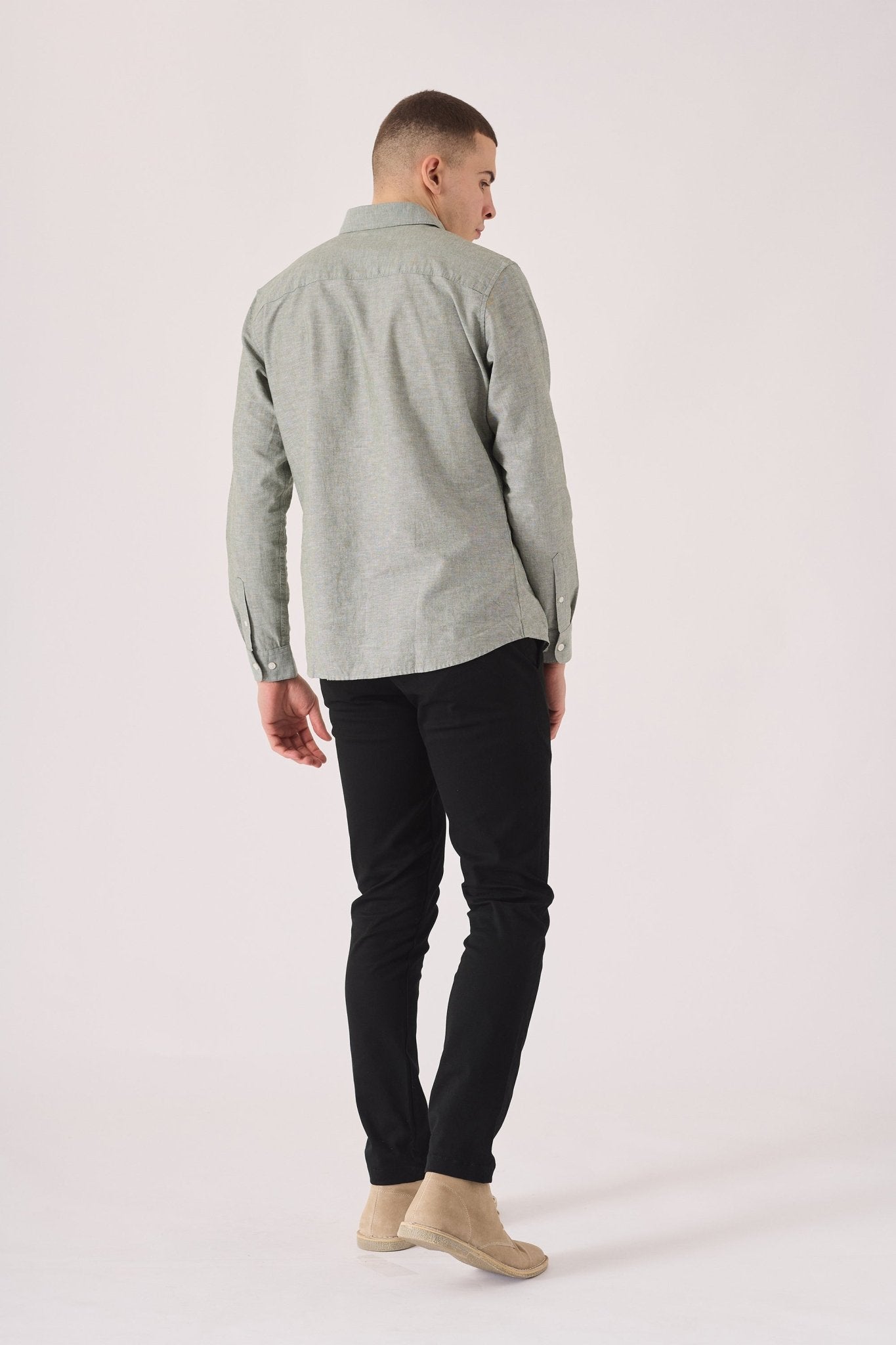 Male model posing in black slim fit chinos trousers.