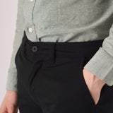 Close up of the front pocket on black slim fit chinos trousers.