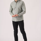 Man wearing black slim fit chinos trousers with a green shirt.