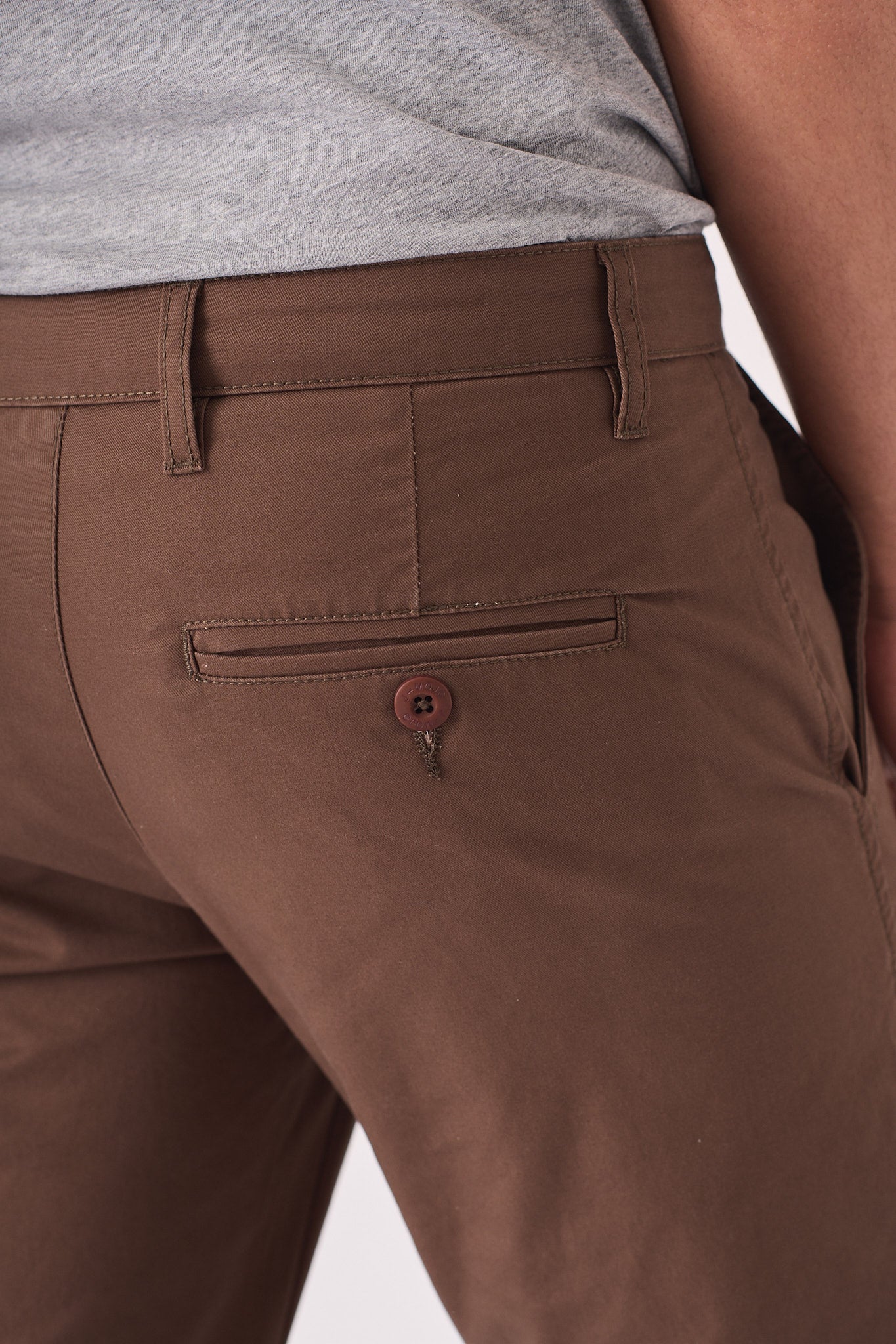 Close up shot of the back pocket on the brown chino trousers.