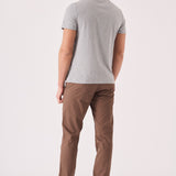 Back view showing the tailored fit of the brown chino trousers.