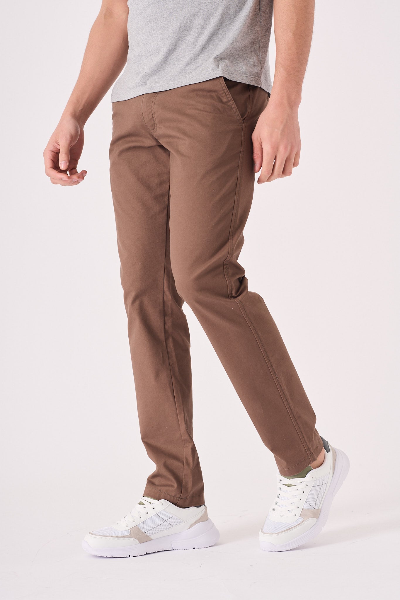 Side angle of a man wearing premium brown chino trousers.