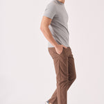 A man walking in stylish brown chino trousers for a modern look.