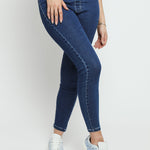 A close up view of the dark blue denim jeggings for women showing the fabric texture and flexible fit.