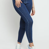 A close up view of the dark blue denim jeggings for women showing the fabric texture and flexible fit.