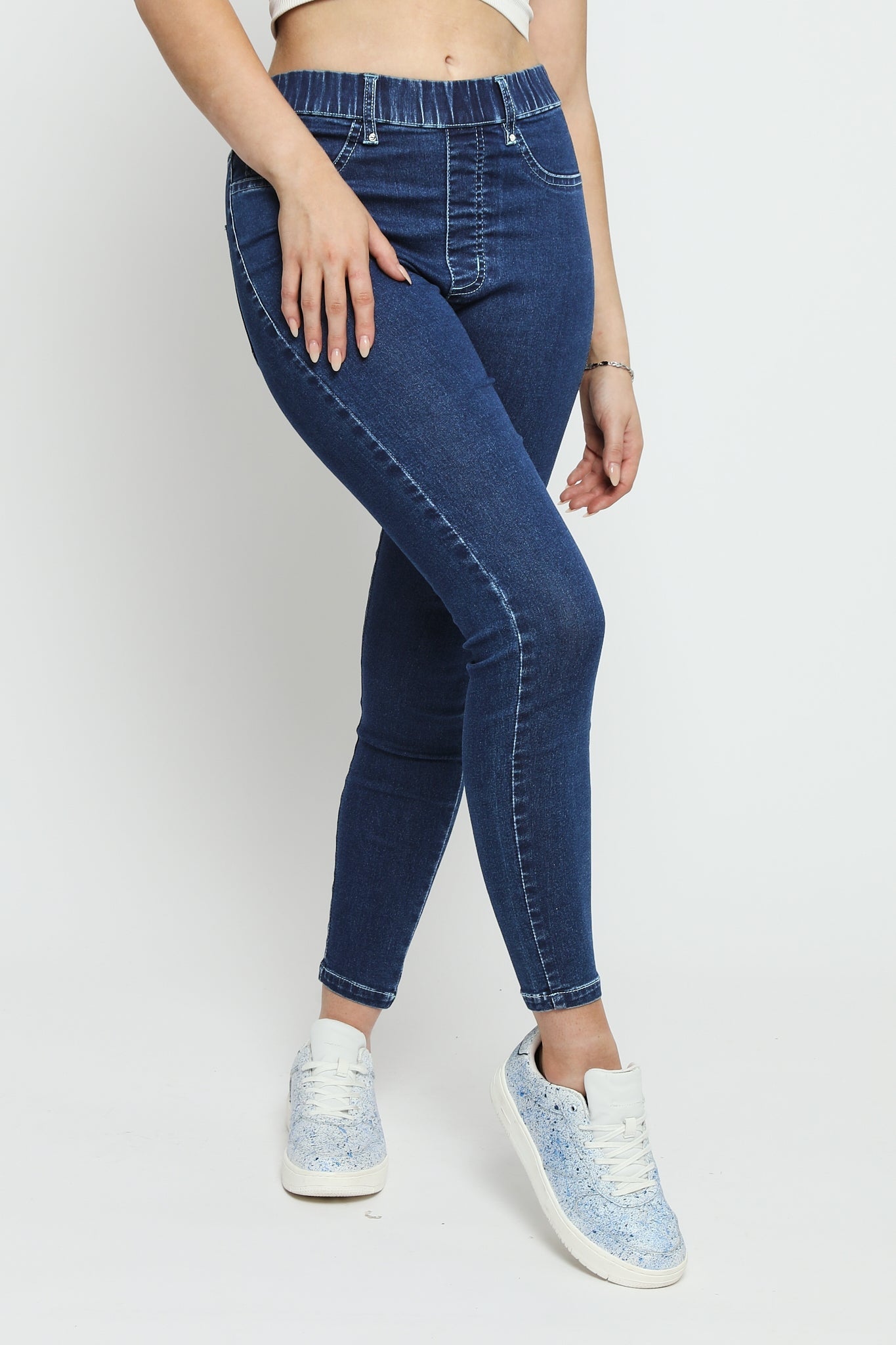 A close up view of the dark blue denim jeggings for women showing the fabric texture and flexible fit.