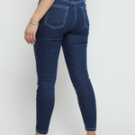 Close up shot of the back of the dark blue denim jeggings for women showing the elasticated waistband and pocket design.