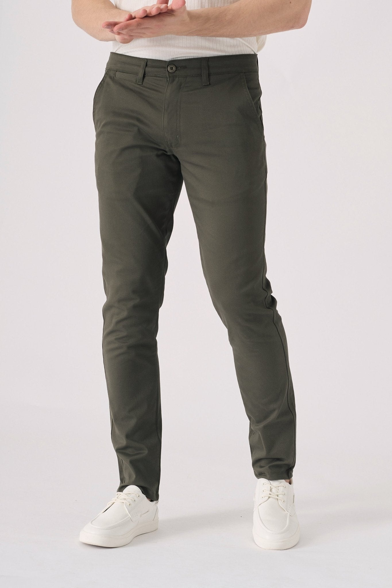 Detail shot of the front pocket area on dark olive green chinos.