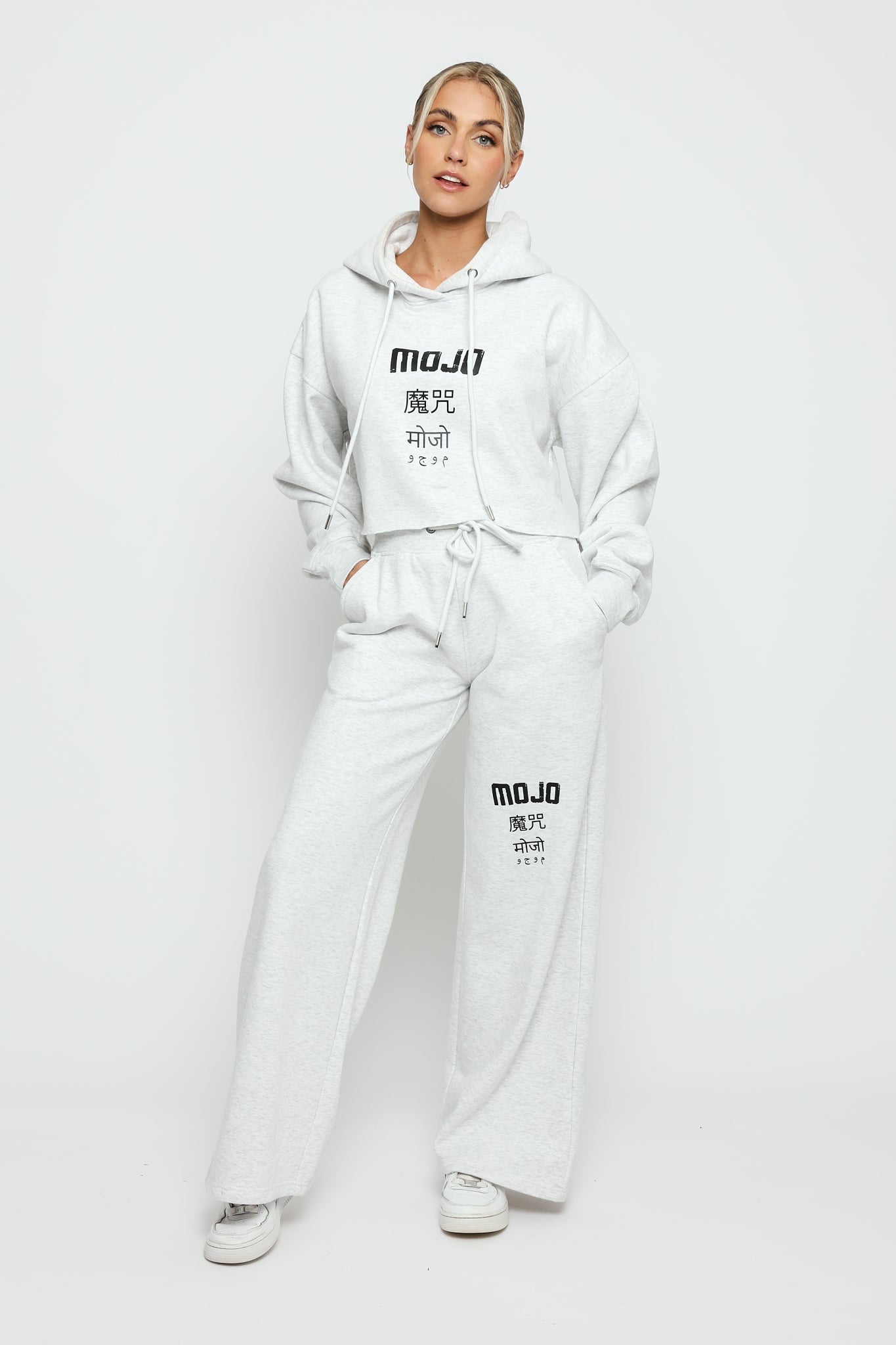 Full length view of a model in a grey marl hoodie women's and matching joggers.