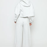 A model walking away in a grey marl hoodie women's.