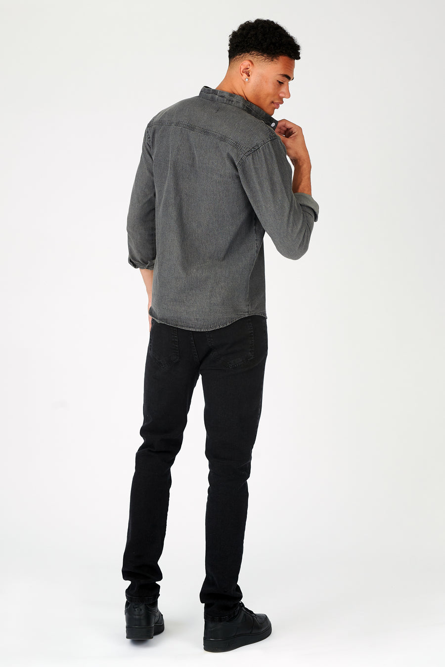 Body back shot of a standing male model wearing a JMOJO Grey Slim Fit Grandad Collar Denim Shirt