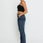 Side profile of the ladies bootcut jeans high waisted highlighting the flared hem.