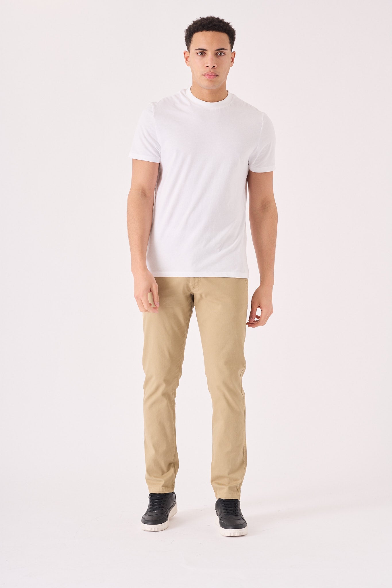 Full front view of a man wearing premium men's beige chinos slim fit.