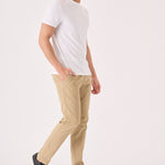 A man walking in stylish men's beige chinos slim fit with a white t-shirt.